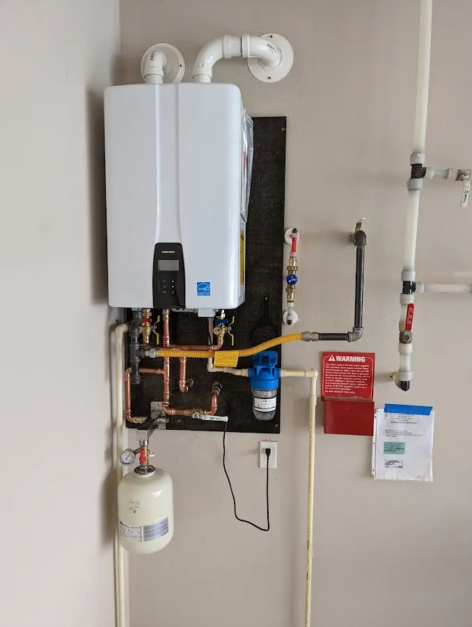 Professional plumber installing copper piping in a Whitmore Village home